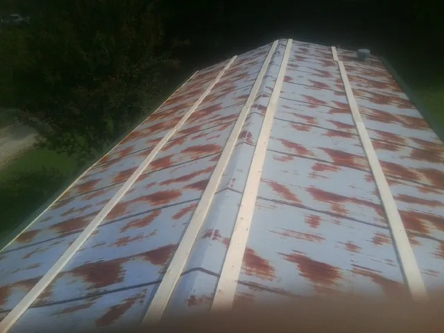 Rusted metal roof panels with new wood purlins before replacement — Storm Damage Roof Repair in Scipio by Roofing Brothers