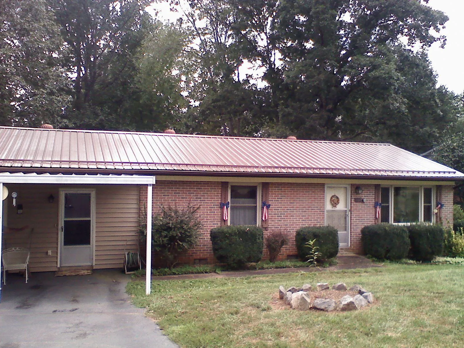 Bronze metal roof and carport on a brick ranch home — Roof Repair work by our crew in Scipio